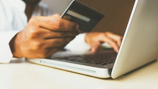 Una persona, haciendo una compra por internet con su tarjeta bancaria. Una persona, haciendo una compra por internet con su tarjeta bancaria.